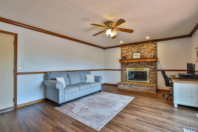 2487 Haddock Dr, Lawrenceburg, IN 47025 - living room featuring a ceiling fan, wood finished floors, crown molding, a desk, and a fireplace