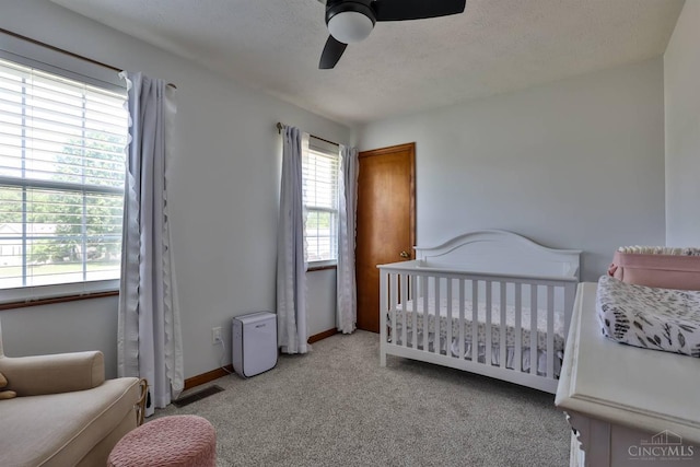 2487 Haddock Dr, Lawrenceburg, IN 47025 - bedroom featuring a nursery area, carpet, ceiling fan, and a textured ceiling