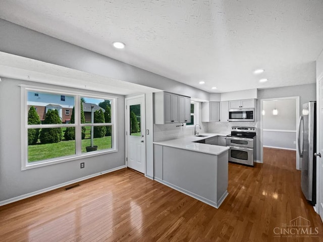 6336 Lansing Ct, Liberty Twp, OH 45011 - kitchen with appliances with stainless steel finishes, gray cabinets, a peninsula, dark wood-type flooring, and recessed lighting
