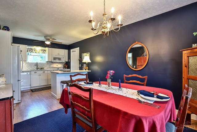 8050 Redhaven Ct, Colerain Twp, OH 45247 - dining area featuring a chandelier, a textured ceiling, wood finished floors, and a ceiling fan