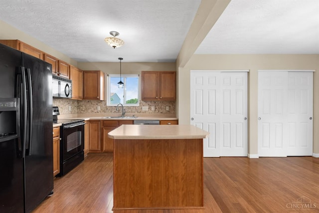 216 Lights Pointe Ct, New Richmond, OH 45157 - kitchen featuring black appliances, wood finished floors, light countertops, tasteful backsplash, and decorative light fixtures