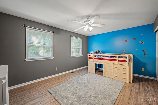 7029 Stonington Rd, Anderson Twp, OH 45230 - bedroom featuring wood finished floors, a ceiling fan, and an accent wall
