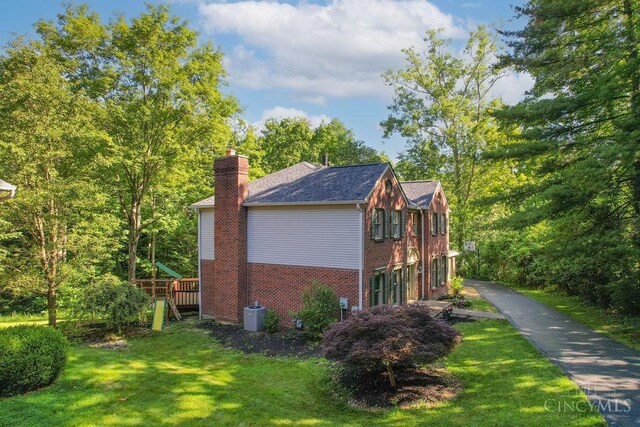7029 Stonington Rd, Anderson Twp, OH 45230 - view of home's exterior featuring brick siding, a chimney, a lawn, and a shingled roof