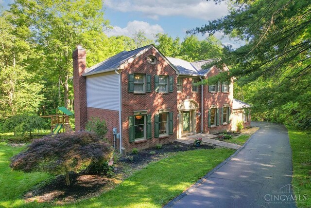 7029 Stonington Rd, Anderson Twp, OH 45230 - view of front of home featuring a chimney, brick siding, a playground, and a front yard