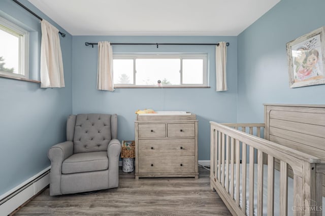 854 Nordyke Rd, Anderson Twp, OH 45255 - bedroom with baseboard heating, a crib, and wood finished floors
