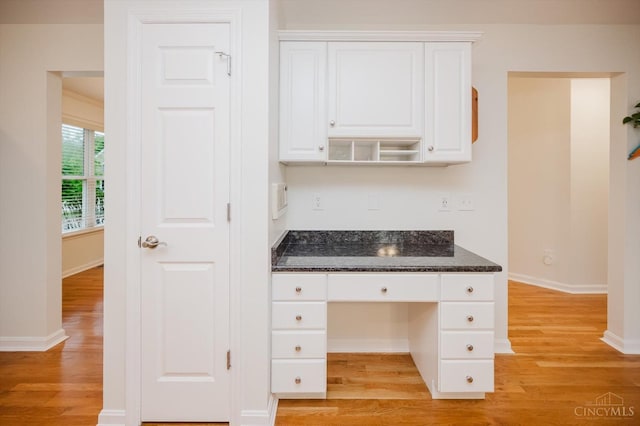 5815 Running Fox Ln, Mason, OH 45040 - kitchen with built in study area, light wood-style floors, white cabinets, and dark stone counters