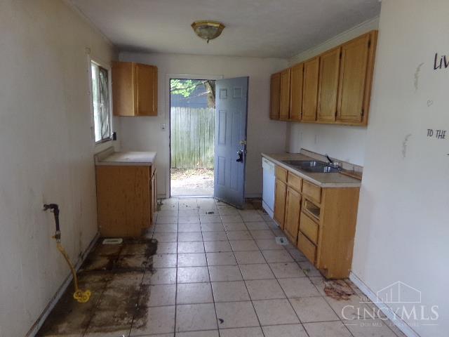 2528 Mariposa Dr, Colerain Twp, OH 45231 - kitchen with light countertops, white dishwasher, brown cabinets, and light tile patterned flooring