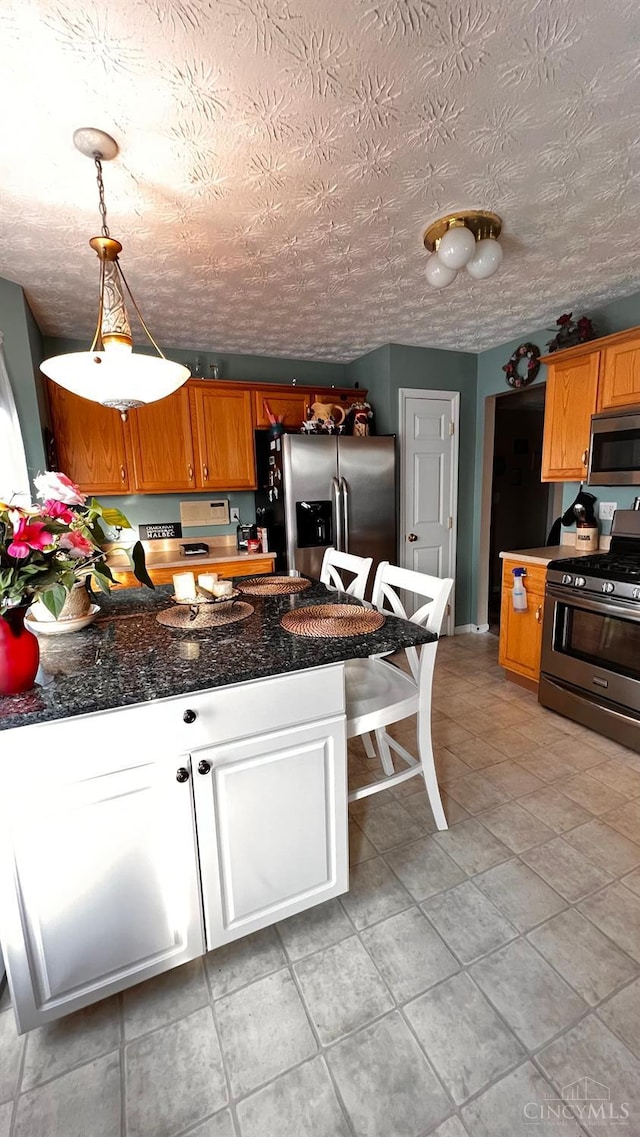 420 Lake Shore Dr, Lebanon, OH 45036 - kitchen featuring appliances with stainless steel finishes, a peninsula, light tile patterned flooring, and brown cabinetry