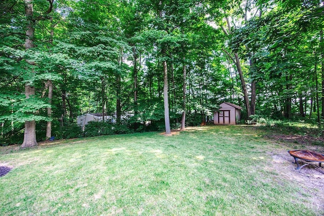 8798 Beckys Ridge Dr, Colerain Twp, OH 45251 - view of grassy yard with a shed and an outdoor fire pit