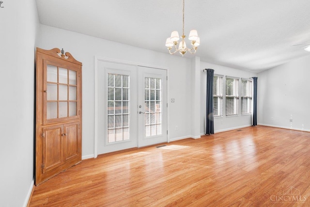 1583 Creekside Rd, Batavia Twp, OH 45102 - unfurnished dining area featuring french doors, light wood-style floors, and a chandelier