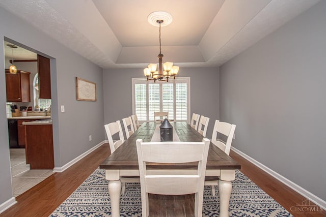 1887 Bantas Creek Rd, Washington Twp, OH 45320 - dining room featuring a tray ceiling, a chandelier, and light wood-style flooring