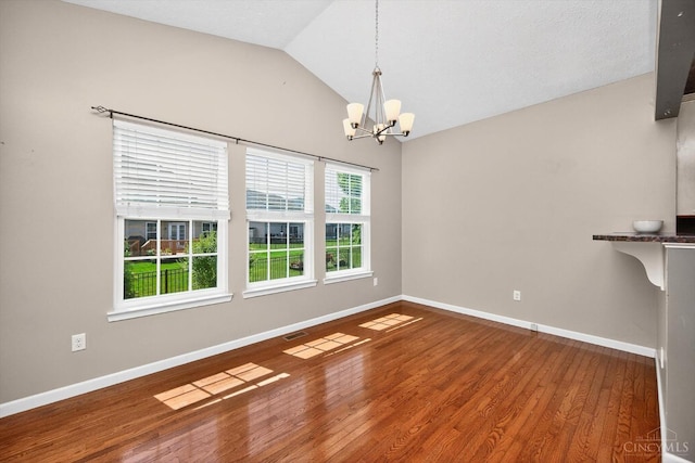 9985 Scotch Pine Dr, Clearcreek Twp, OH 45066 - empty room with a chandelier, vaulted ceiling, and wood finished floors