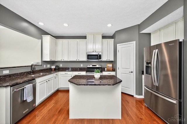 9985 Scotch Pine Dr, Clearcreek Twp, OH 45066 - kitchen with appliances with stainless steel finishes, dark wood-style floors, dark stone counters, a center island, and recessed lighting