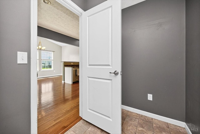 9985 Scotch Pine Dr, Clearcreek Twp, OH 45066 - corridor featuring a textured ceiling, a chandelier, and vaulted ceiling