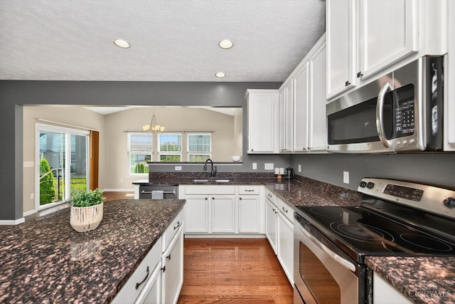 9985 Scotch Pine Dr, Clearcreek Twp, OH 45066 - kitchen featuring stainless steel appliances, white cabinets, a chandelier, wood finished floors, and dark stone countertops