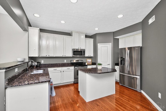9985 Scotch Pine Dr, Clearcreek Twp, OH 45066 - kitchen with stainless steel appliances, dark stone counters, a center island, white cabinetry, and recessed lighting
