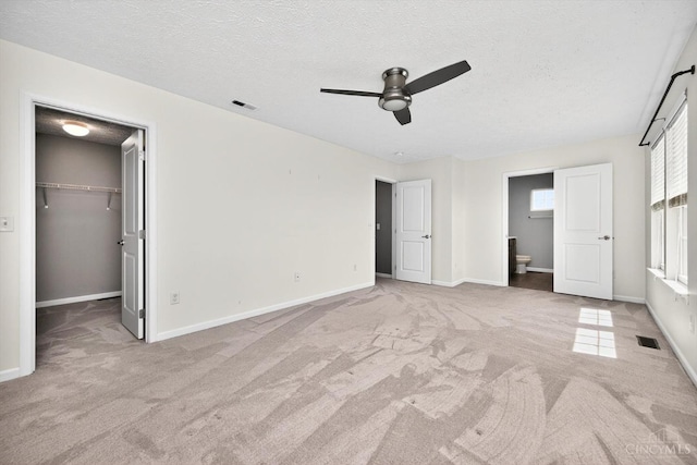 9985 Scotch Pine Dr, Clearcreek Twp, OH 45066 - unfurnished bedroom with carpet, a spacious closet, a textured ceiling, ensuite bath, and ceiling fan