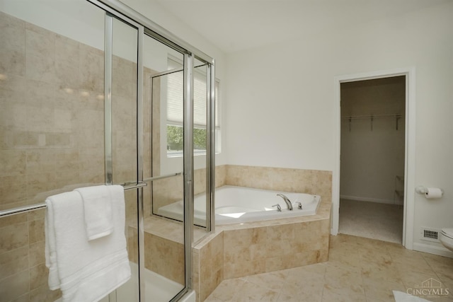 688 Humock Ct, Hamilton Twp, OH 45039 - full bath with a garden tub, a stall shower, a spacious closet, and tile patterned flooring
