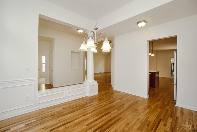 688 Humock Ct, Hamilton Twp, OH 45039 - unfurnished room featuring a chandelier, light wood-style flooring, and a wainscoted wall