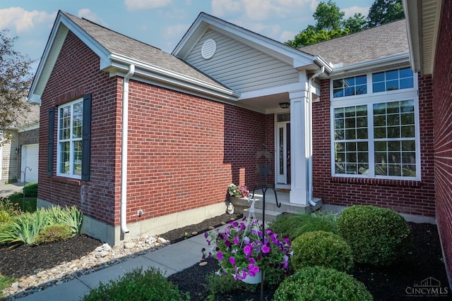 688 Humock Ct, Hamilton Twp, OH 45039 - view of side of property featuring brick siding, an attached garage, and a shingled roof