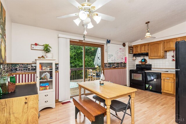 1167 Muirwood Ln, Union Twp, OH 45103 - kitchen with black appliances, under cabinet range hood, light wood-style floors, brown cabinetry, and vaulted ceiling