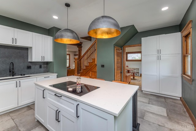521 S Main St, Franklin, OH 45005 - kitchen featuring black electric cooktop, decorative backsplash, light countertops, white cabinets, and recessed lighting