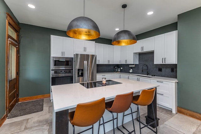 521 S Main St, Franklin, OH 45005 - kitchen featuring appliances with stainless steel finishes, decorative backsplash, a kitchen island, light countertops, and recessed lighting