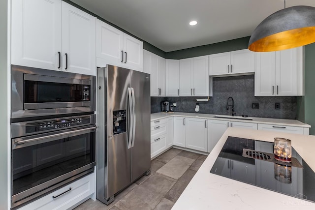 521 S Main St, Franklin, OH 45005 - kitchen featuring appliances with stainless steel finishes, tasteful backsplash, white cabinetry, pendant lighting, and light stone counters