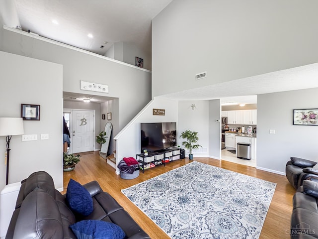 3649 Pebble Creek Ct, Mason, OH 45040 - living room featuring a towering ceiling, stairs, light wood-style flooring, and recessed lighting