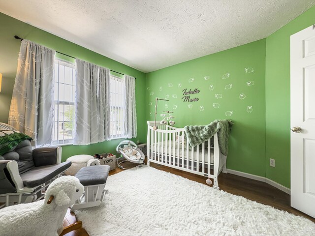 3649 Pebble Creek Ct, Mason, OH 45040 - bedroom with wood finished floors, a textured ceiling, and a nursery area