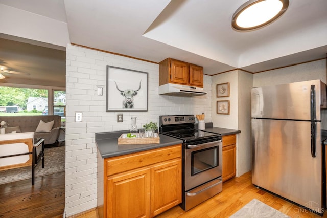 8385 Bridle Rd, Anderson Twp, OH 45244 - kitchen with appliances with stainless steel finishes, under cabinet range hood, dark countertops, and light wood finished floors