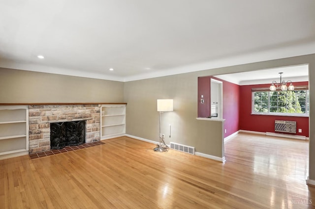 1006 Harbury Dr, Springfield Twp, OH 45224 - unfurnished living room with wood finished floors, a stone fireplace, a chandelier, and recessed lighting