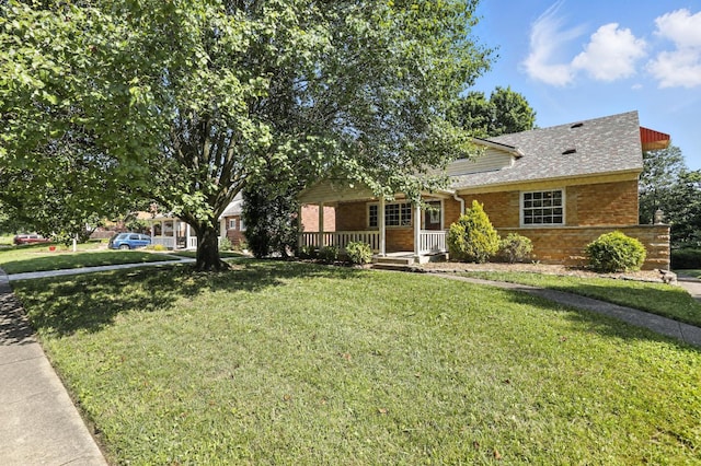 1006 Harbury Dr, Springfield Twp, OH 45224 - view of front facade with covered porch, brick siding, a front lawn, and a shingled roof