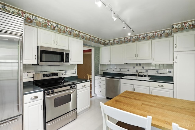 1006 Harbury Dr, Springfield Twp, OH 45224 - kitchen with appliances with stainless steel finishes, white cabinets, tasteful backsplash, and dark countertops