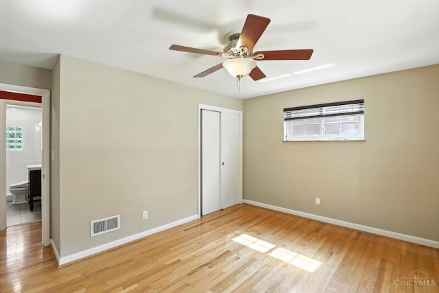 1006 Harbury Dr, Springfield Twp, OH 45224 - unfurnished bedroom with multiple windows, light wood-style flooring, a closet, and a ceiling fan