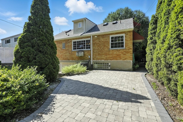 1006 Harbury Dr, Springfield Twp, OH 45224 - back of house featuring brick siding and roof with shingles