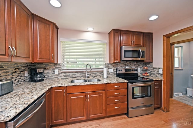 3638 El Rego Dr, Pierce Twp, OH 45102 - kitchen with appliances with stainless steel finishes, light wood-type flooring, light stone countertops, tasteful backsplash, and recessed lighting