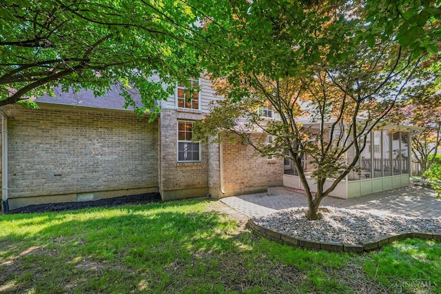 125 Sackett Dr, Monroe, OH 45050 - view of side of home featuring a sunroom, brick siding, a yard, and a patio area