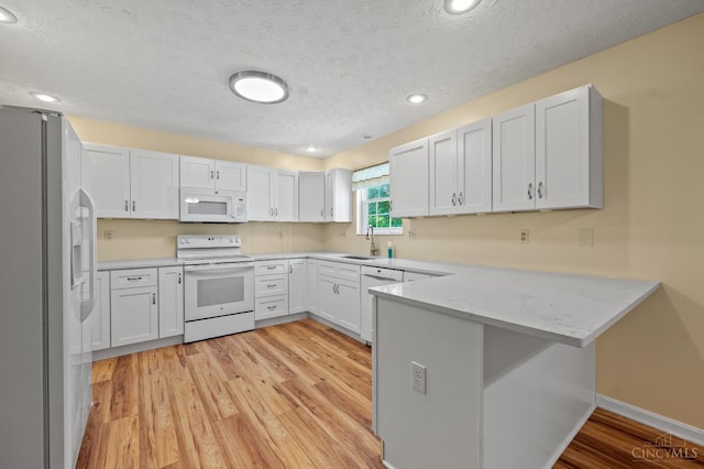 125 Sackett Dr, Monroe, OH 45050 - kitchen with white appliances, a peninsula, a textured ceiling, light wood finished floors, and recessed lighting