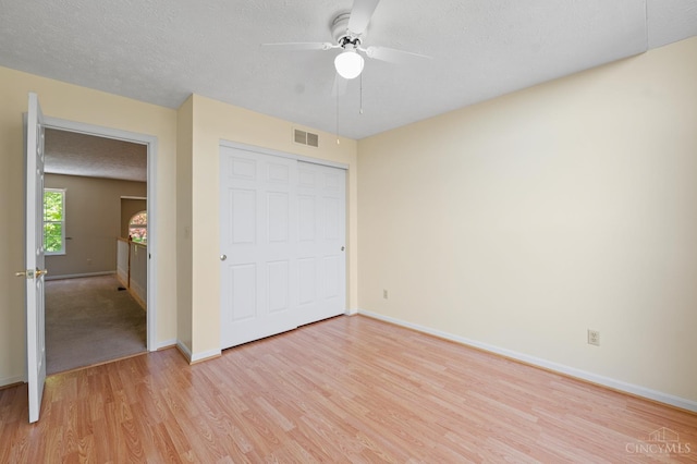125 Sackett Dr, Monroe, OH 45050 - unfurnished bedroom featuring light wood-type flooring, a closet, a textured ceiling, and a ceiling fan