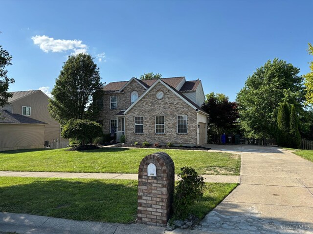 742 Miami Way Dr, Hamilton, OH 45013 - traditional-style home featuring concrete driveway, a front lawn, a garage, and stone siding