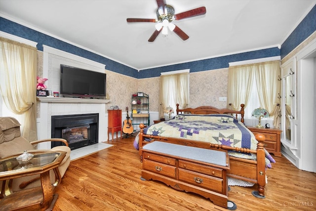 1001 Shawhan Rd, Union Twp, OH 45152 - bedroom featuring wood finished floors, a fireplace with flush hearth, crown molding, wallpapered walls, and a ceiling fan