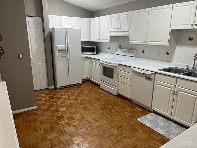12061 Carrington Ln Unit 206, Symmes Twp, OH 45140 - kitchen with white appliances, under cabinet range hood, tasteful backsplash, white cabinets, and vaulted ceiling