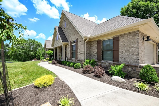 18092 Horizon Way, Lawrenceburg, IN 47025 - view of side of home with a yard, roof with shingles, a garage, stone siding, and brick siding