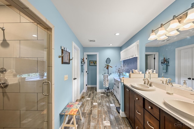 18092 Horizon Way, Lawrenceburg, IN 47025 - bathroom featuring double vanity, wood finished floors, a shower stall, and recessed lighting