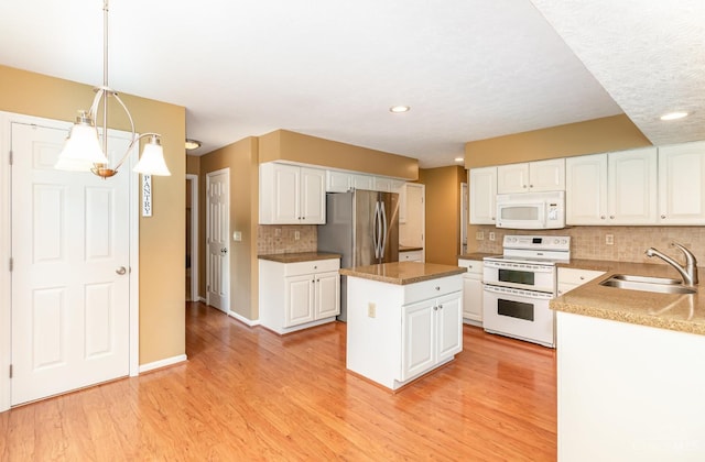 7693 Misty Springs Ct, Deerfield Twp, OH 45040 - kitchen featuring white appliances, decorative backsplash, a kitchen island, white cabinetry, and recessed lighting