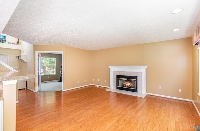 7693 Misty Springs Ct, Deerfield Twp, OH 45040 - unfurnished living room with a fireplace, a textured ceiling, light wood-type flooring, and recessed lighting
