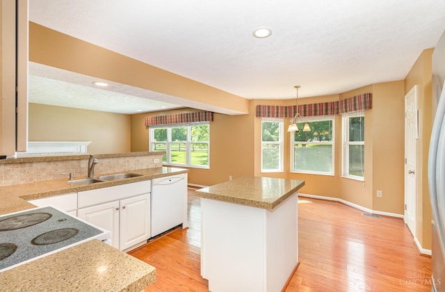 7693 Misty Springs Ct, Deerfield Twp, OH 45040 - kitchen featuring dishwasher, white cabinets, light wood-type flooring, hanging light fixtures, and recessed lighting