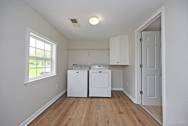 5782 Buckwheat Rd, Miami Twp, OH 45150 - laundry area featuring washer and dryer, cabinet space, and light wood-style flooring