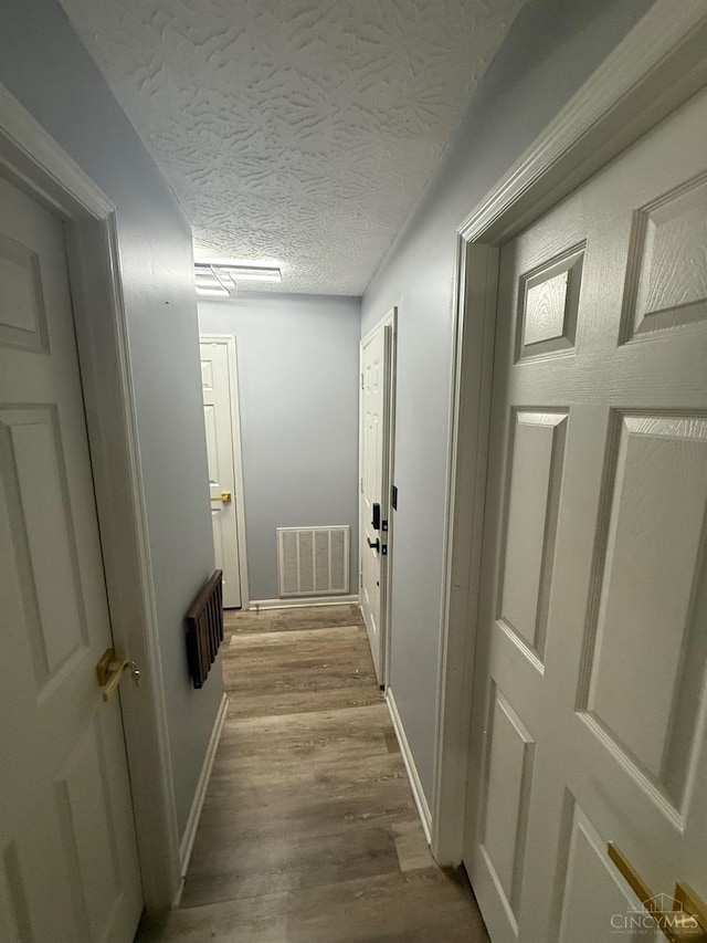 7912 Jessies Way Unit 304, Fairfield Twp, OH 45011 - hallway featuring wood finished floors and a textured ceiling